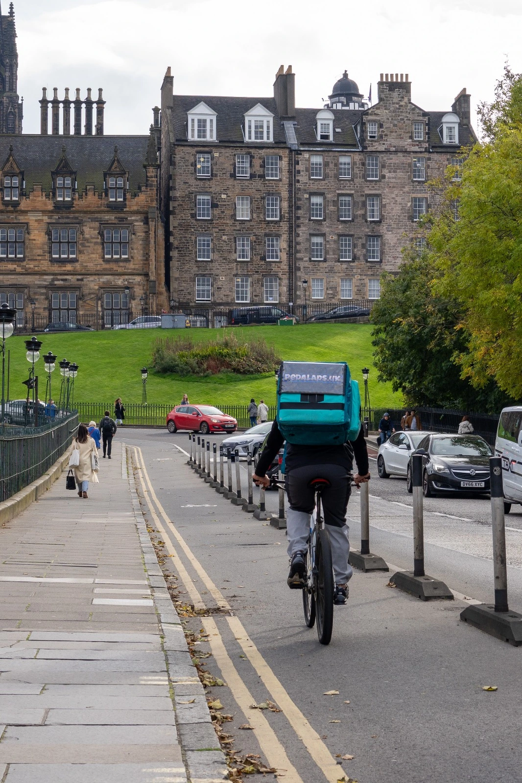 Display screen on bike rider bag showing restaurant advertisement in Edinburgh city center