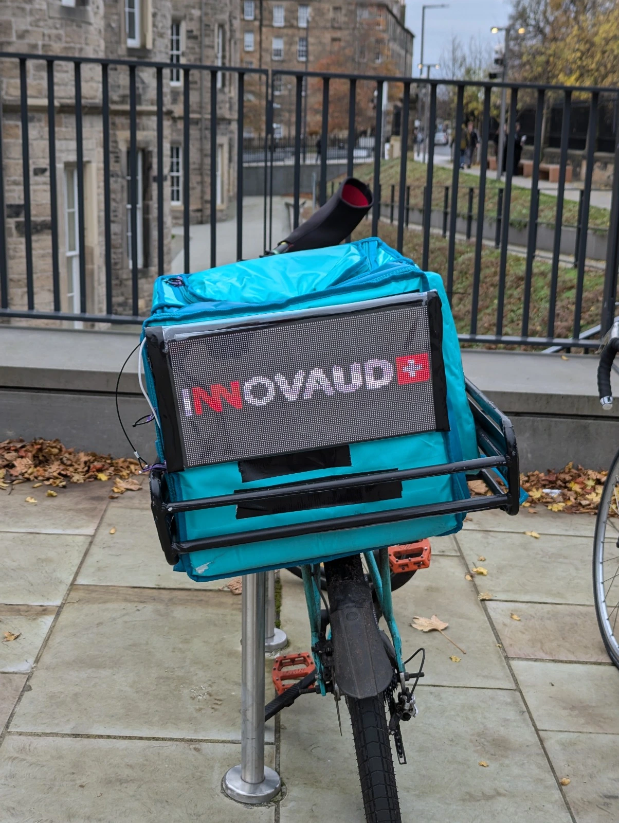 Mobile display advertising system mounted on bike rider bag during Edinburgh delivery