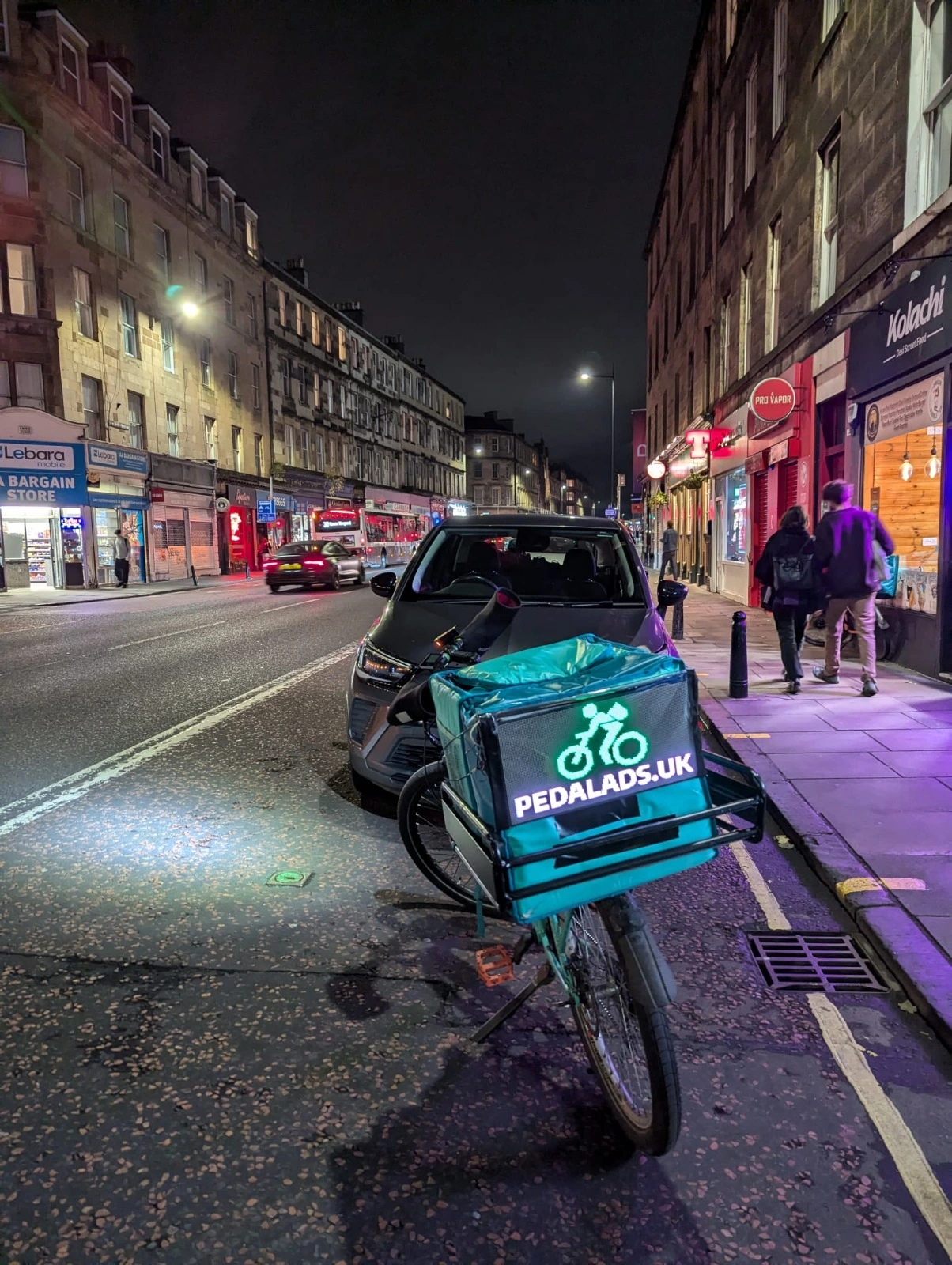 Bike rider with advertising display panel cycling through Edinburgh's Royal Mile